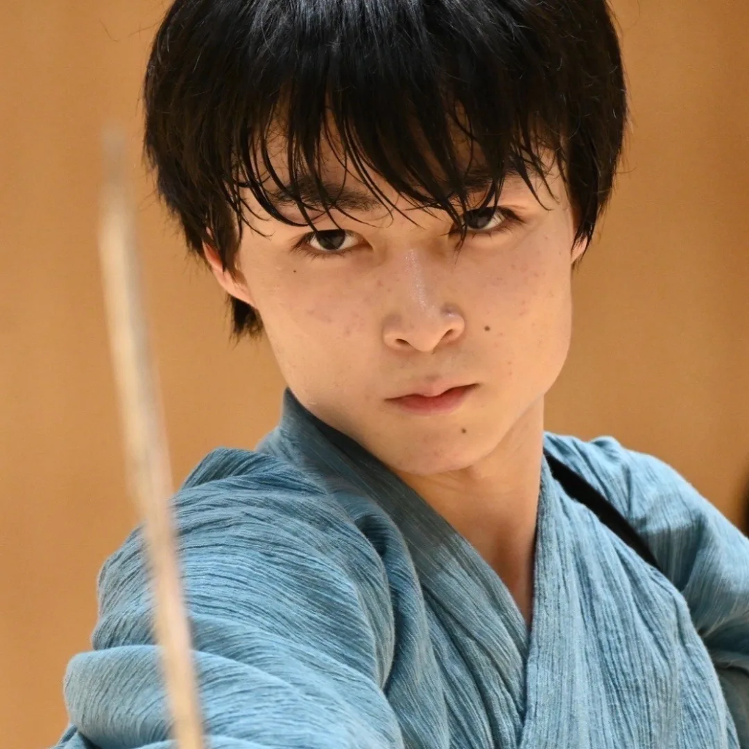 Close-up portrait of Yuusei Uchida, a young Japanese man intensely holding a katana