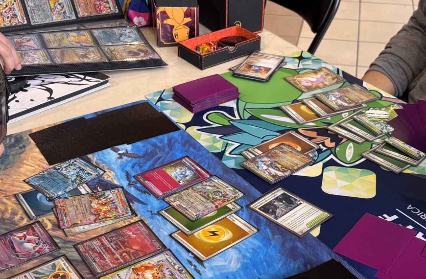 Two people playing the Pokémon Trading Card Game at a table, with cards arranged on colorful playmats.
