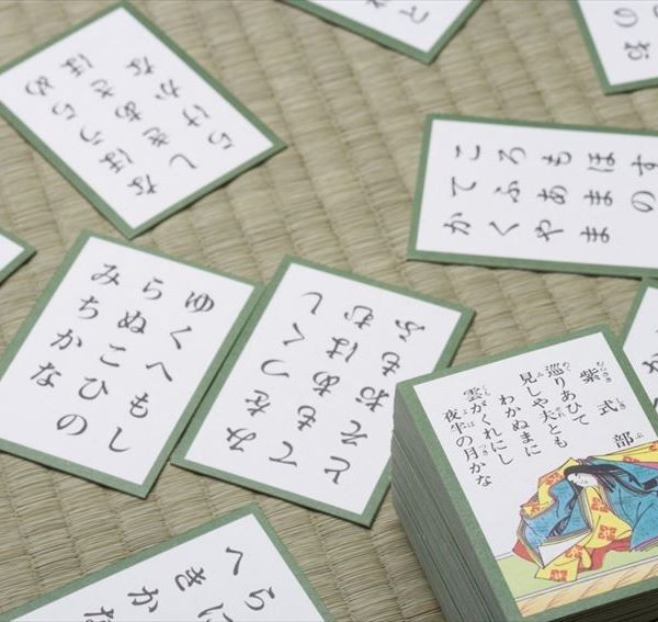 a collection of traditional Japanese Karuta cards scattered across a textured tatami mat.