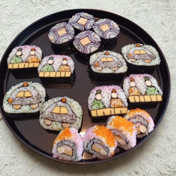 Plates of art sushi in the shapes of a snowman, hina dolls, and christmas.