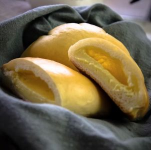 3 yellow cream pans in a grey towel in sunlight.