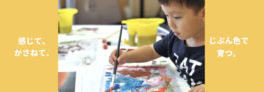 A serious young boy painting with watercolours.