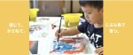 A serious young boy painting with watercolours.