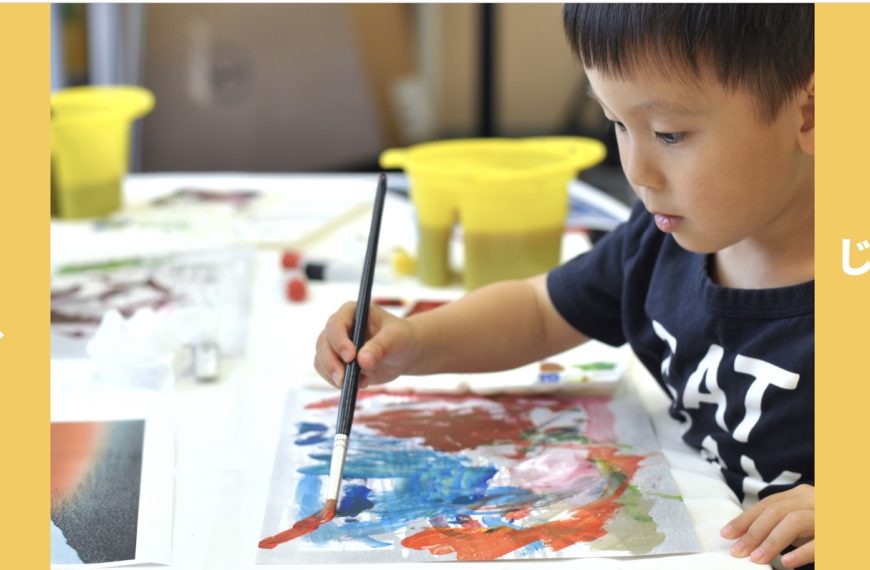 A serious young boy painting with watercolours.