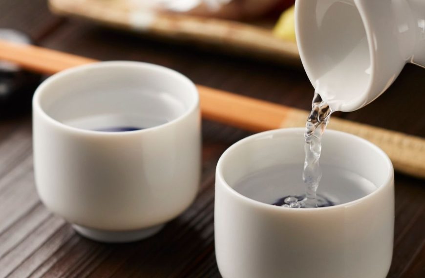 Pouring sake into two while porcelain cups.