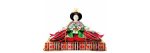 Traditional Japanese Hina doll in an elaborate multi-layered kimono and golden crown, holding a decorative fan while seated.