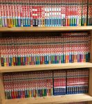 Three layers of bookshelves packed with Japanese manga books.