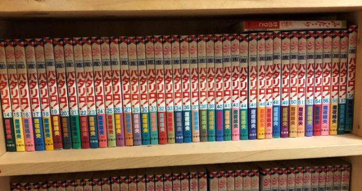 Three layers of bookshelves packed with Japanese manga books.